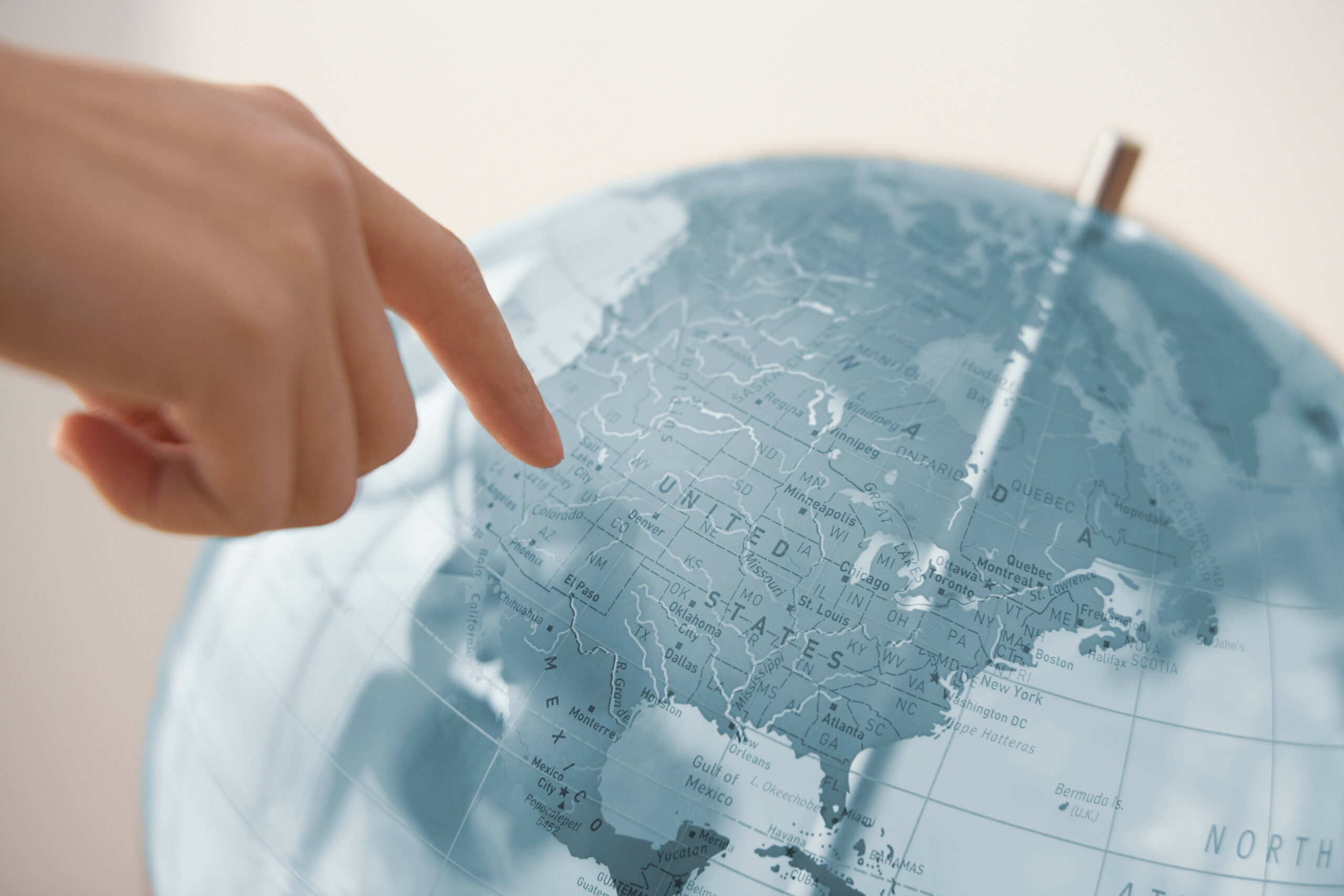 Person pointing at a globe